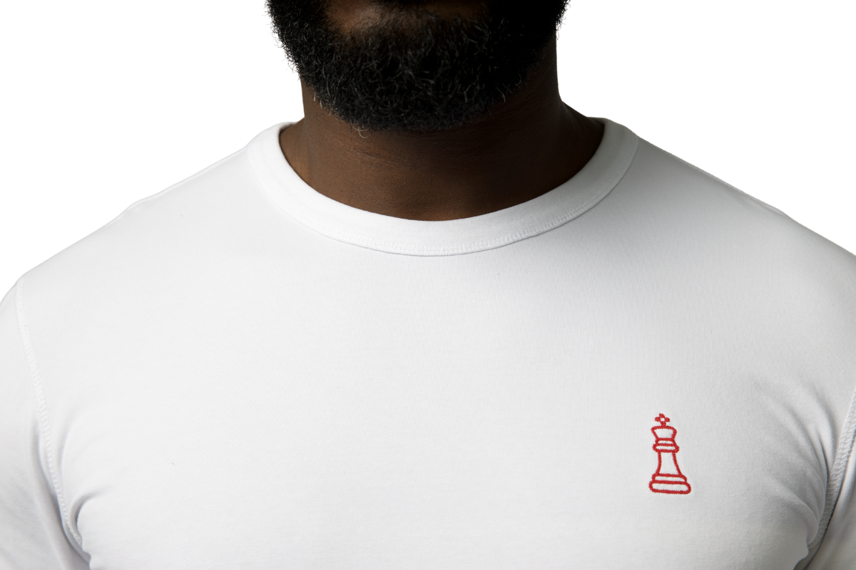 ODYCÉ Signature Longsleeve St. Moritz Weiß – Detailaufnahme roter Chess King Stick